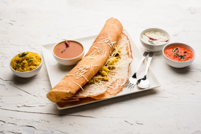 Cheese Masala dosa is a South Indian meal served with sambhar and coconut chutney.