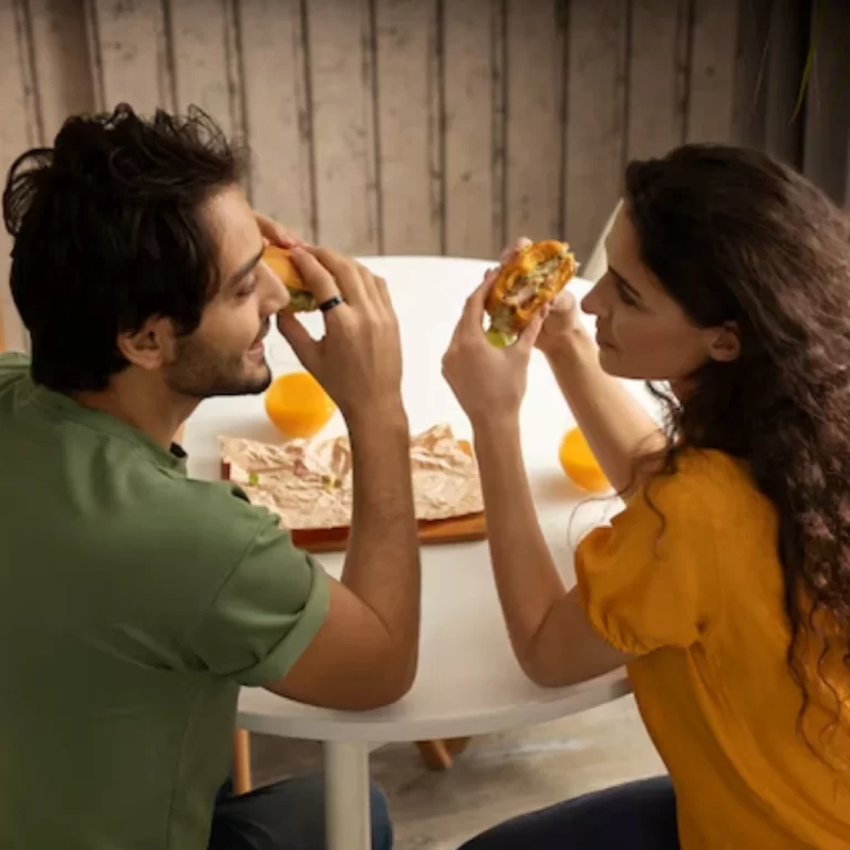 An Indian couple enjoying burgers together at home