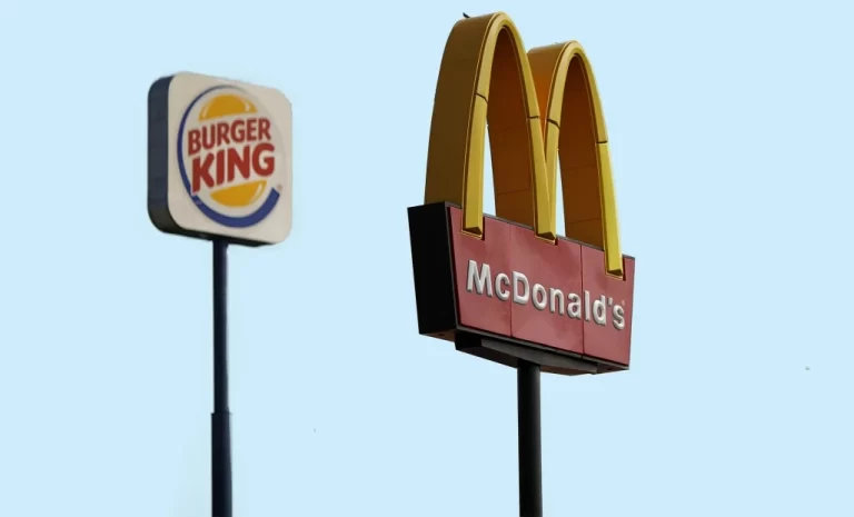 Two signboards of a McDonald’s and a Burger King appear next to each other