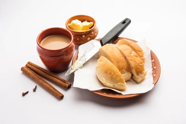 Bun-maska Tea or bun Maska chai that is cut in half and laden with wholesome butter.